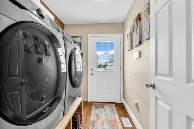 clothes washing area featuring separate washer and dryer and dark wood-type flooring