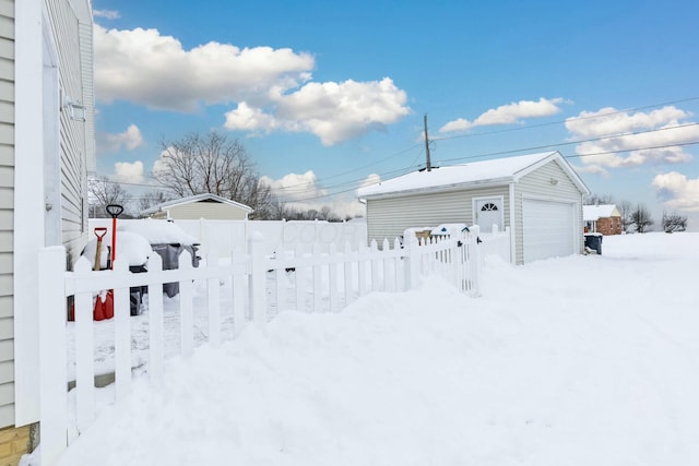 snowy yard with an outbuilding and a garage