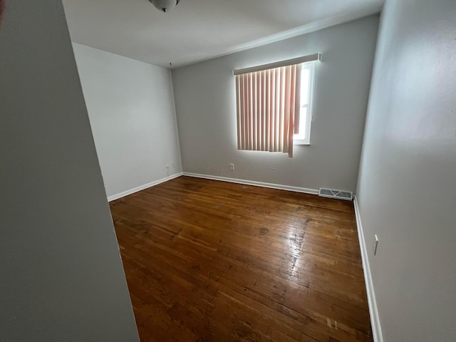 unfurnished room with dark wood-type flooring