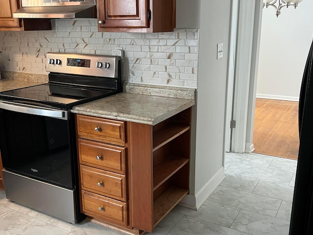 kitchen featuring stainless steel range with electric stovetop, tasteful backsplash, and black refrigerator