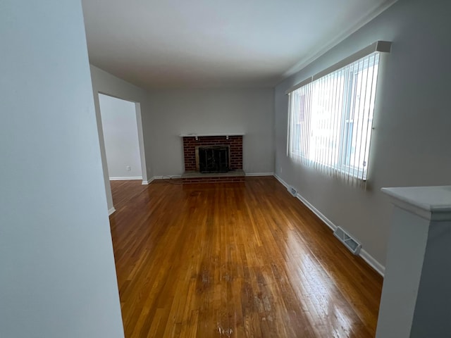 unfurnished living room featuring a fireplace and wood-type flooring