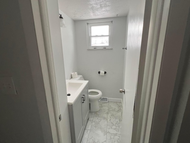 bathroom featuring vanity, toilet, and a textured ceiling