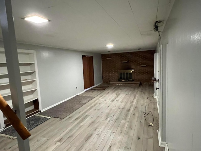 basement with a fireplace and light hardwood / wood-style floors