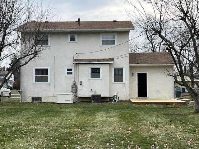 back of property with central air condition unit and a lawn