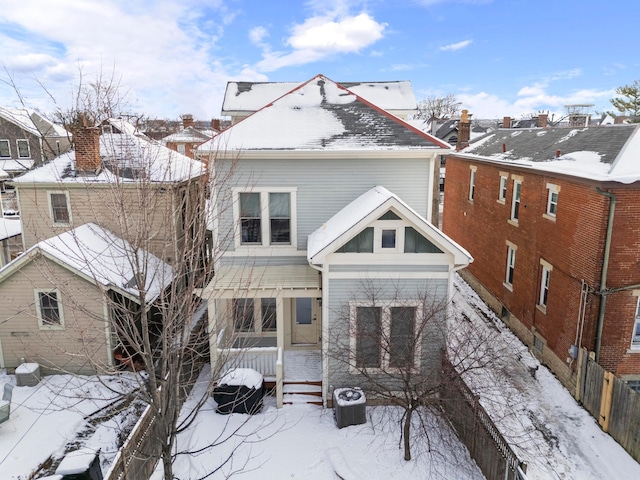 snow covered house with central AC