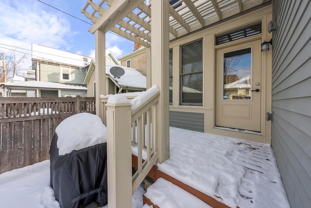 snow covered deck with a pergola and area for grilling