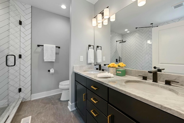 bathroom featuring vanity, a shower with shower door, and toilet