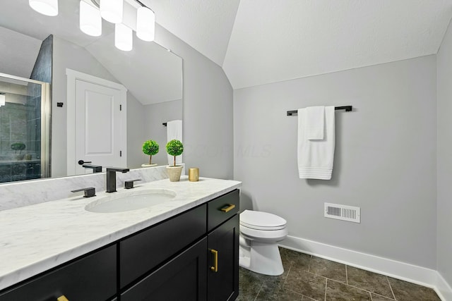 bathroom with walk in shower, vanity, vaulted ceiling, and toilet