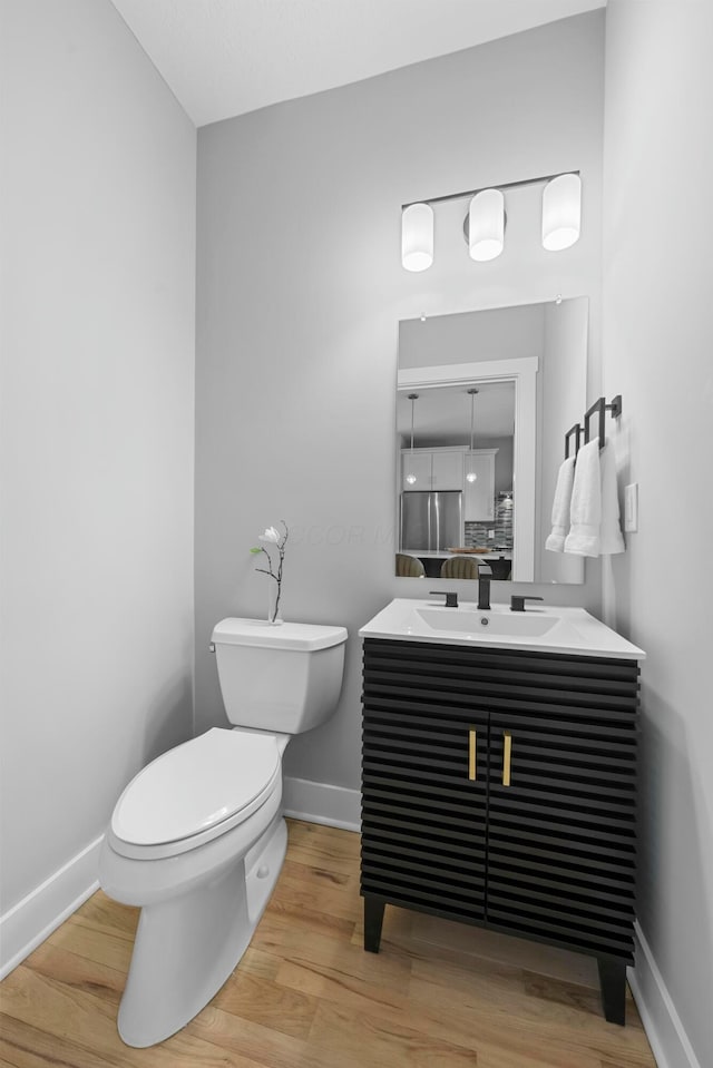 bathroom featuring vanity, toilet, and wood-type flooring