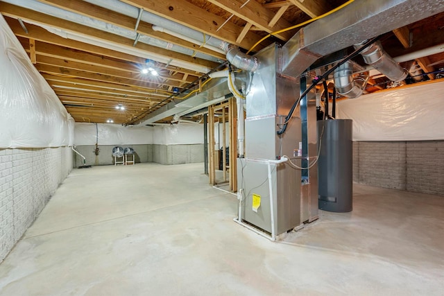 basement with heating unit, water heater, and brick wall