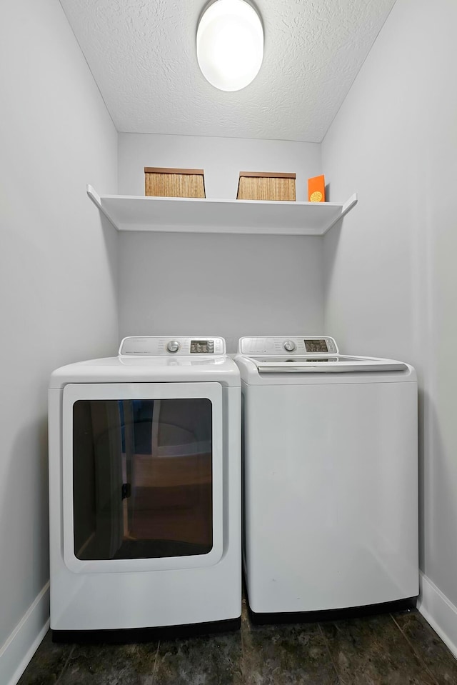 washroom with a textured ceiling and washing machine and dryer