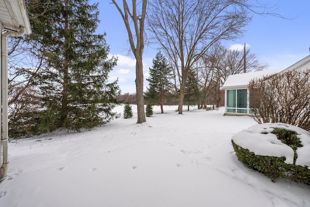 yard layered in snow with a sunroom