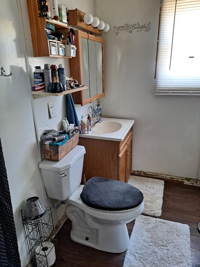 bathroom featuring toilet, vanity, and hardwood / wood-style flooring