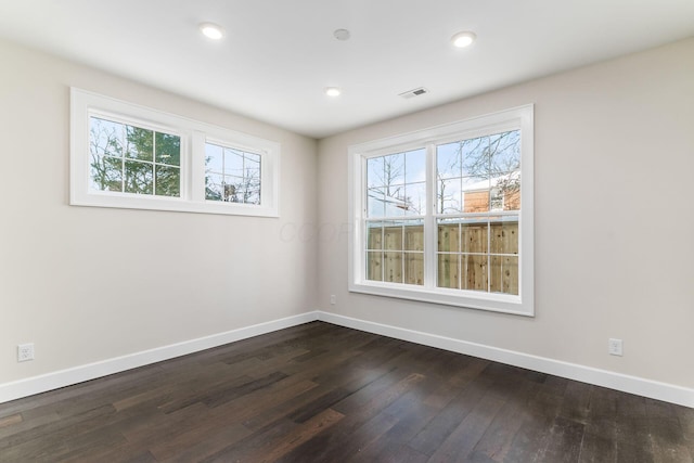 unfurnished room with a healthy amount of sunlight and dark hardwood / wood-style floors