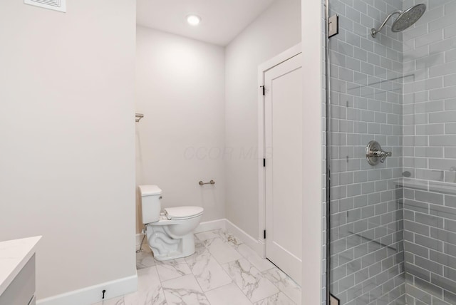 bathroom with tiled shower, vanity, and toilet