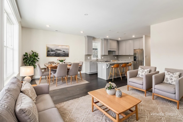 living room featuring plenty of natural light, hardwood / wood-style floors, and sink