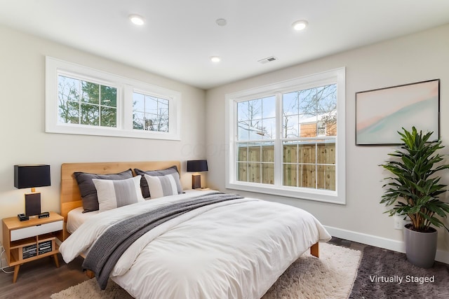 bedroom with dark hardwood / wood-style flooring and multiple windows