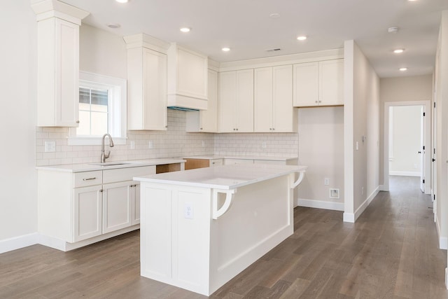 2015 W 5th Ave Unit 211, Columbus, OH 43212 - kitchen featuring white cabinets, dark hardwood / wood-style floors, a center island, and sink
