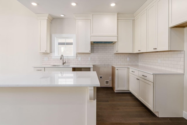 2015 W 5th Ave Unit 211, Columbus, OH 43212 - kitchen with decorative backsplash, white cabinetry, sink, and dark wood-type flooring