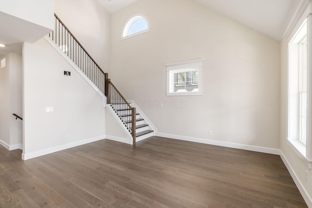2015 W 5th Ave Unit 211, Columbus, OH 43212 - unfurnished living room with high vaulted ceiling, a wealth of natural light, and dark wood-type flooring