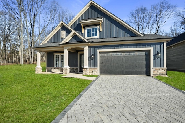 view of front facade with a garage, a front yard, and covered porch