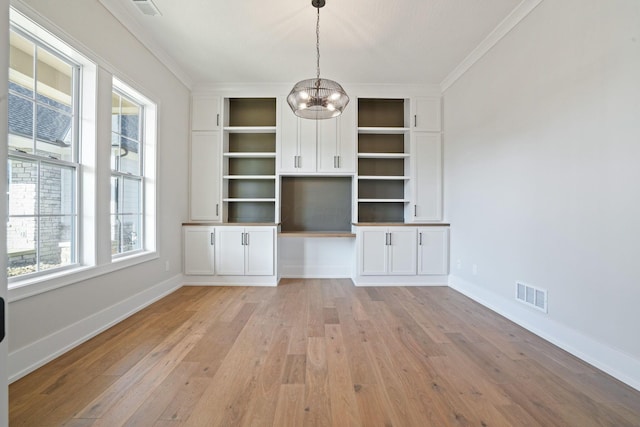 unfurnished office featuring ornamental molding, a chandelier, and light wood-type flooring