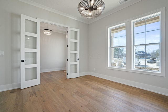 unfurnished bedroom with french doors, ornamental molding, a chandelier, and light hardwood / wood-style flooring