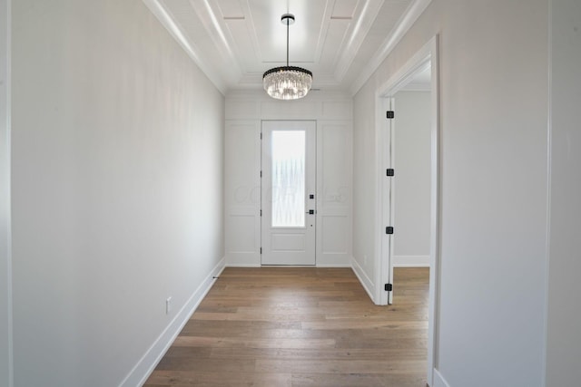 entrance foyer with ornamental molding, a notable chandelier, and light hardwood / wood-style floors