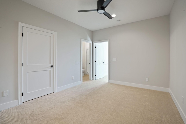 unfurnished bedroom featuring ensuite bathroom, light carpet, and ceiling fan