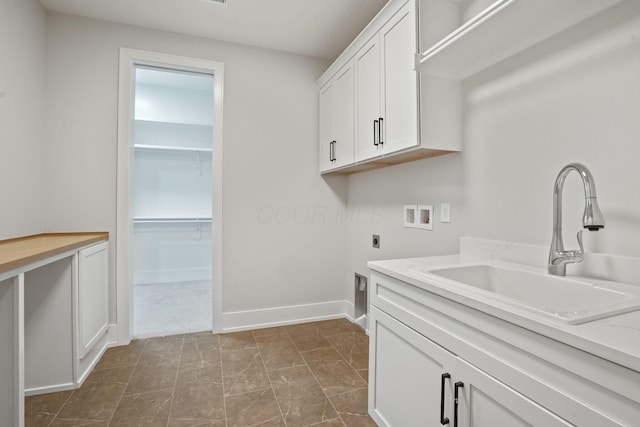 washroom featuring electric dryer hookup, sink, hookup for a washing machine, and cabinets