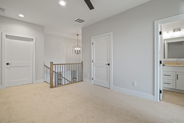 interior space featuring light carpet, sink, and an inviting chandelier