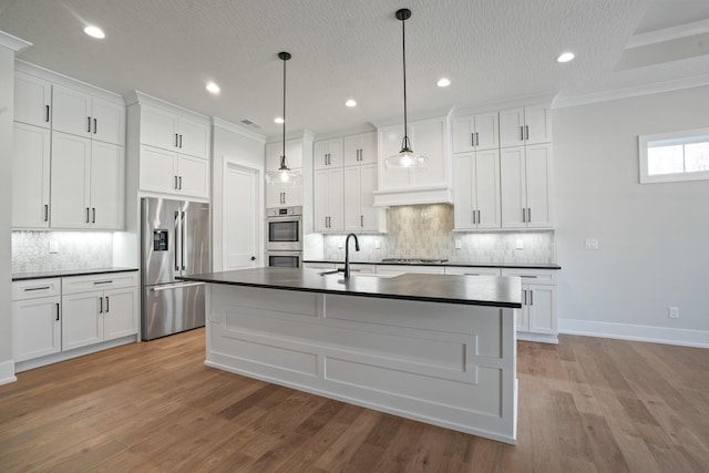 kitchen with hanging light fixtures, white cabinetry, appliances with stainless steel finishes, and sink