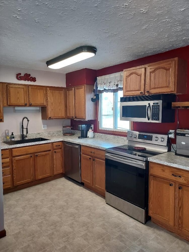 kitchen with sink, stainless steel appliances, and a textured ceiling