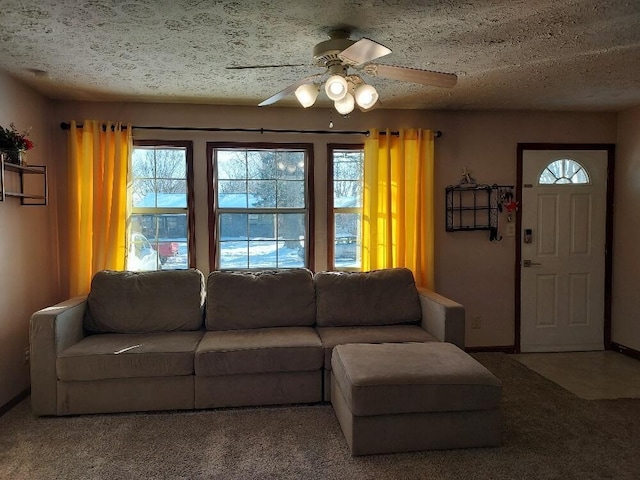 carpeted living room featuring ceiling fan and a textured ceiling