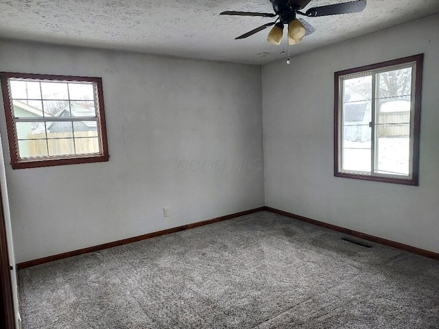 empty room with carpet, ceiling fan, and a textured ceiling