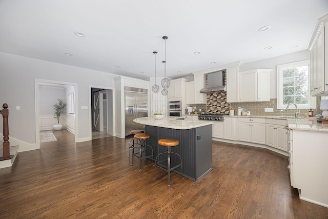 kitchen with white cabinetry, hanging light fixtures, stainless steel appliances, dark hardwood / wood-style flooring, and a kitchen island