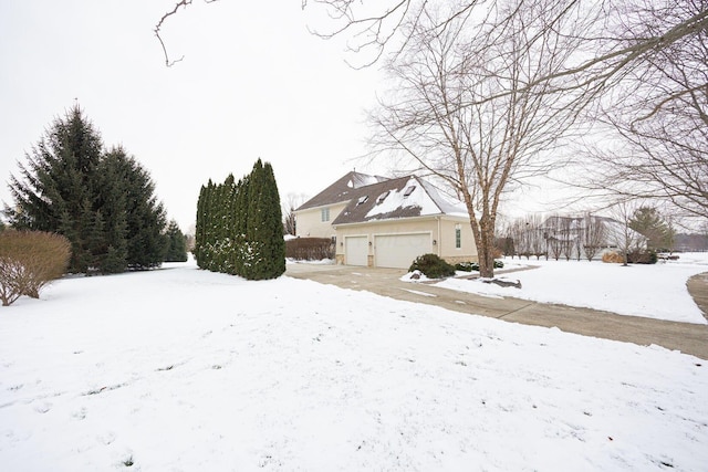 yard covered in snow featuring a garage