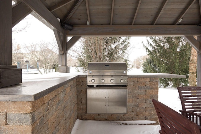 snow covered patio with area for grilling and grilling area