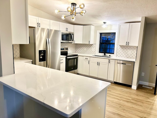 kitchen with white cabinets, appliances with stainless steel finishes, and kitchen peninsula