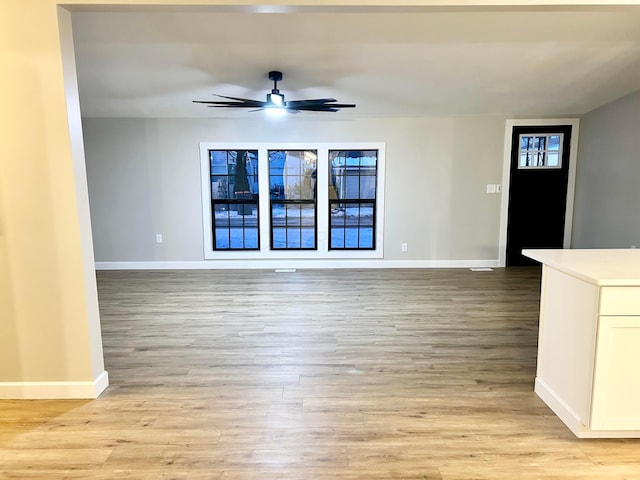 unfurnished living room featuring ceiling fan and light wood-type flooring