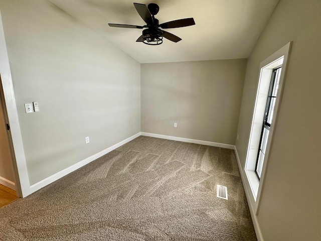 carpeted empty room with ceiling fan and lofted ceiling