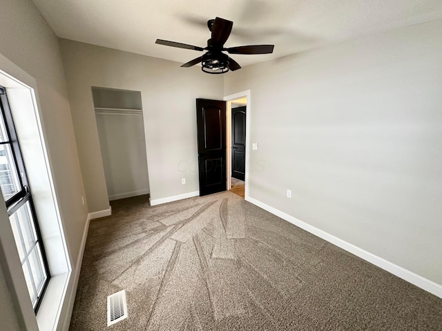 unfurnished bedroom featuring ceiling fan, carpet, and a closet