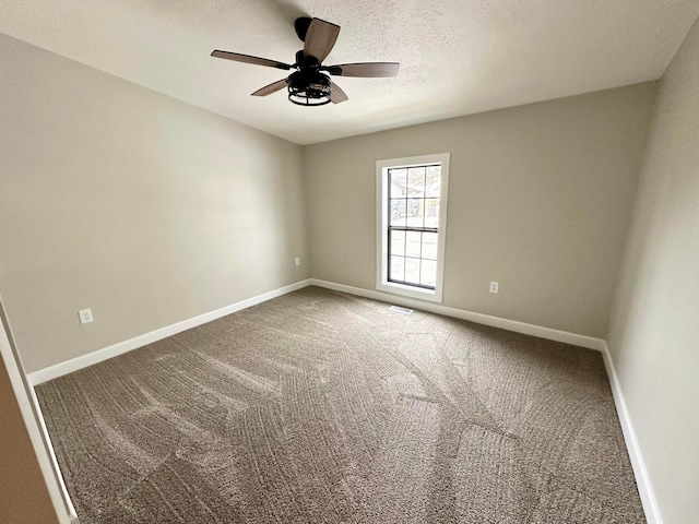 carpeted spare room with ceiling fan and a textured ceiling