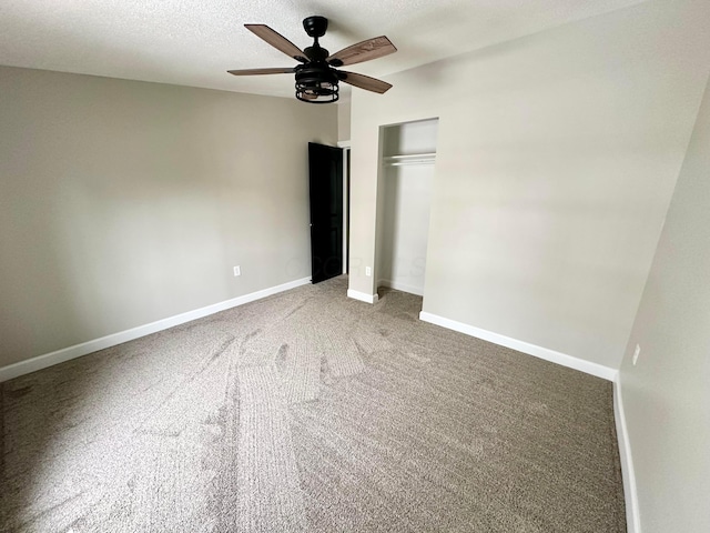 unfurnished bedroom with a textured ceiling, ceiling fan, a closet, and carpet floors