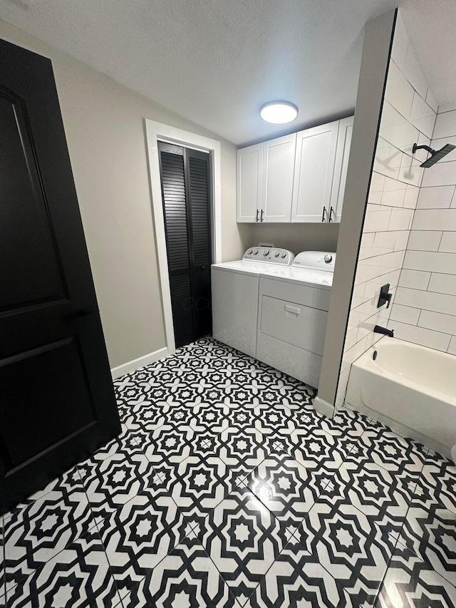 laundry area featuring cabinets, a textured ceiling, and washing machine and dryer