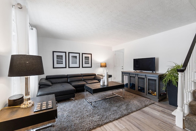 living room featuring light hardwood / wood-style floors and a textured ceiling