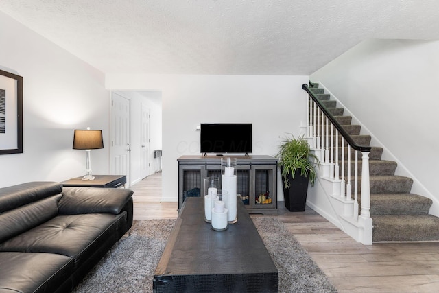 living room with wood-type flooring and a textured ceiling