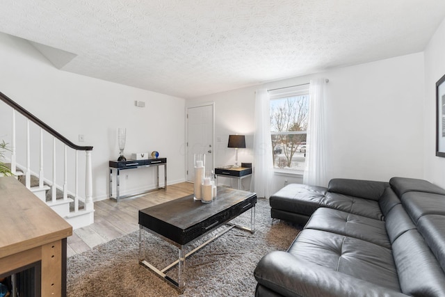 living room featuring a textured ceiling and light hardwood / wood-style flooring