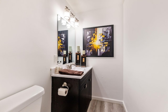 bathroom featuring toilet, vanity, and hardwood / wood-style floors