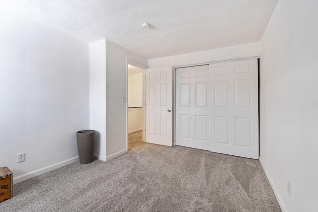 unfurnished bedroom with a closet and carpet flooring